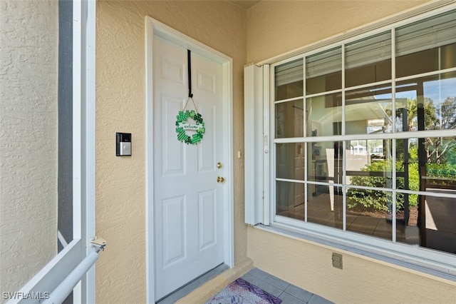 view of exterior entry featuring stucco siding