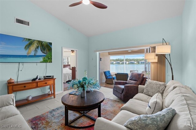 living room featuring a water view, high vaulted ceiling, ceiling fan, and visible vents