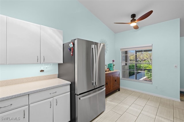 kitchen with freestanding refrigerator, white cabinets, light countertops, and baseboards