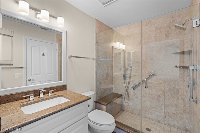 bathroom with toilet, a stall shower, visible vents, and vanity