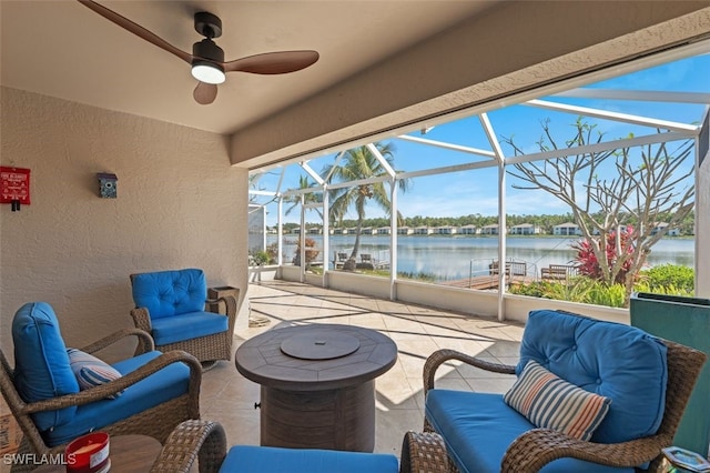 view of patio with a water view, glass enclosure, outdoor lounge area, and a ceiling fan