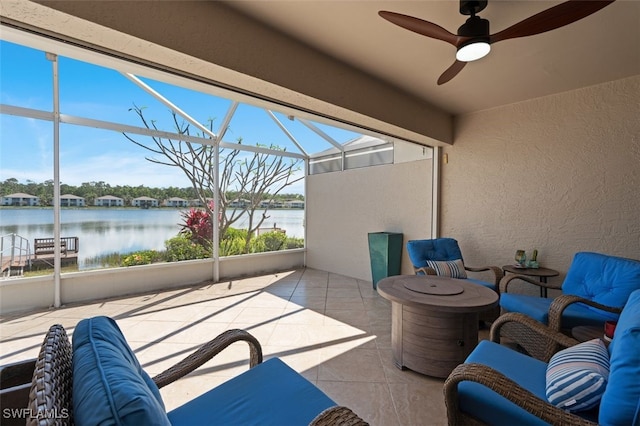 view of patio featuring ceiling fan, a water view, and a lanai