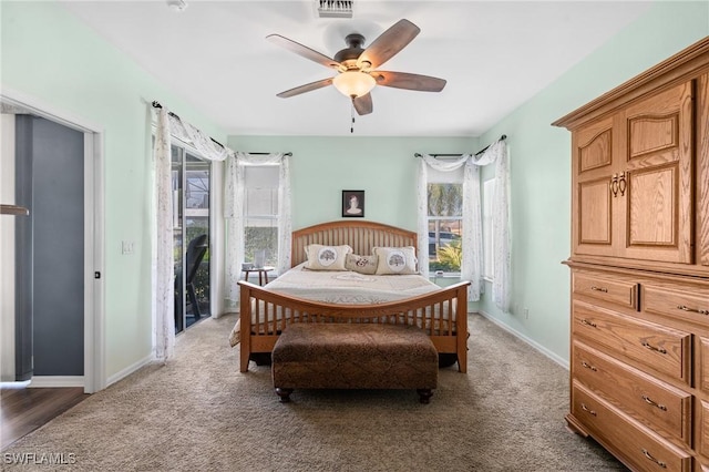 carpeted bedroom with access to exterior, visible vents, ceiling fan, and baseboards