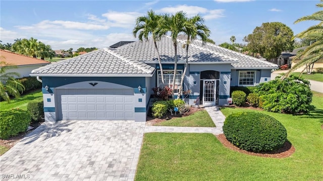 view of front of house featuring a front lawn, decorative driveway, a tile roof, and an attached garage