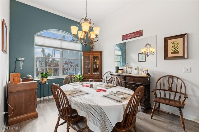 dining area featuring wood finished floors, baseboards, and an inviting chandelier