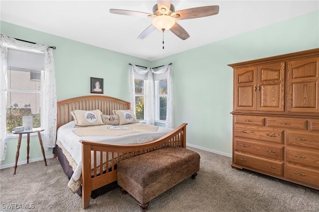 bedroom featuring light carpet, a ceiling fan, and baseboards