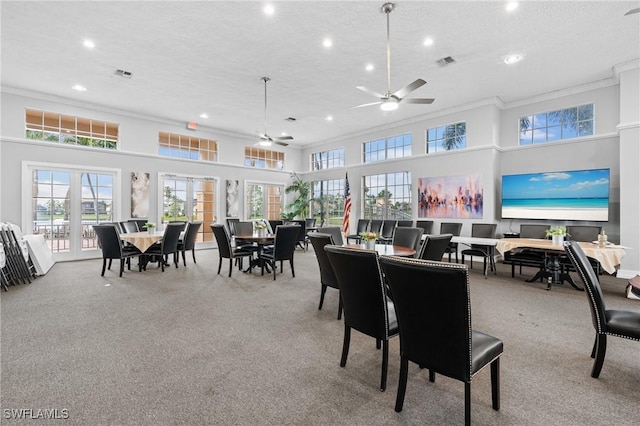 dining area with a textured ceiling, french doors, a high ceiling, and visible vents