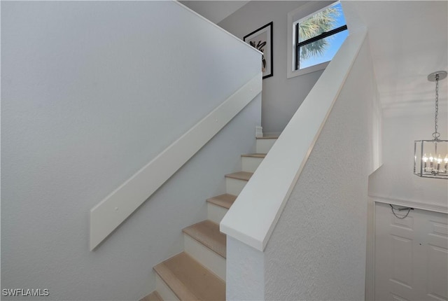 stairs with a chandelier