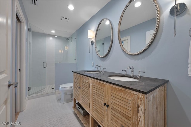 full bathroom featuring toilet, a stall shower, visible vents, and a sink