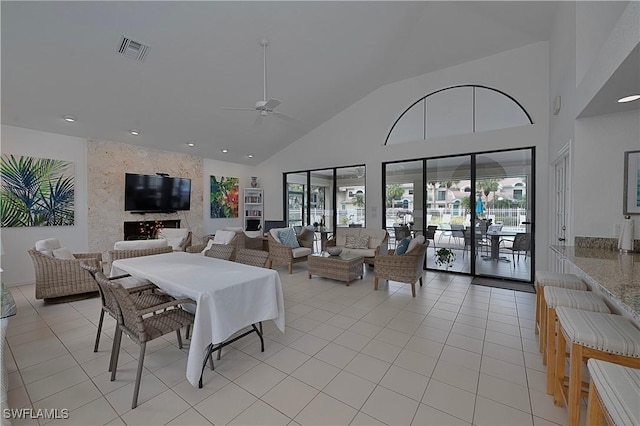 dining space with high vaulted ceiling, plenty of natural light, visible vents, and light tile patterned flooring