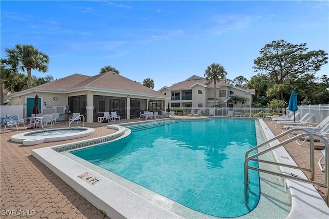 community pool featuring a community hot tub, a patio, and fence