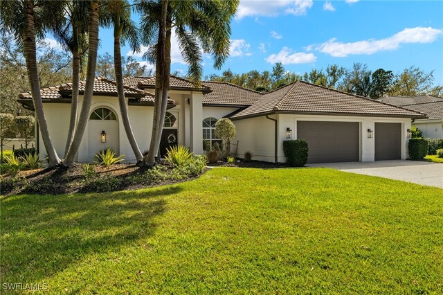 mediterranean / spanish-style home with a garage, driveway, a tile roof, a front yard, and stucco siding