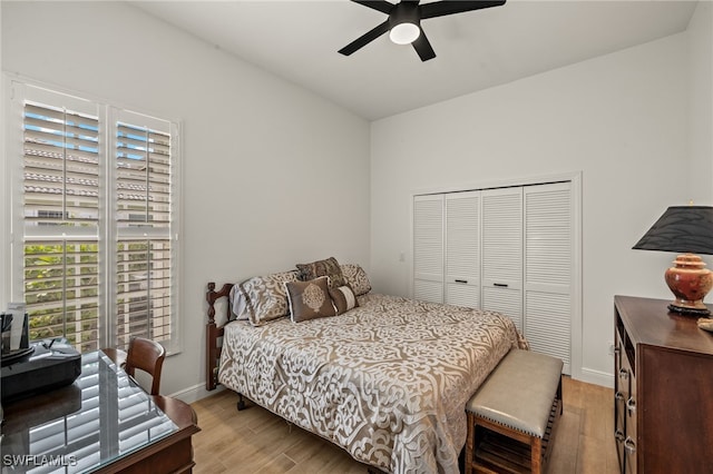 bedroom with light wood-style floors, a closet, baseboards, and a ceiling fan