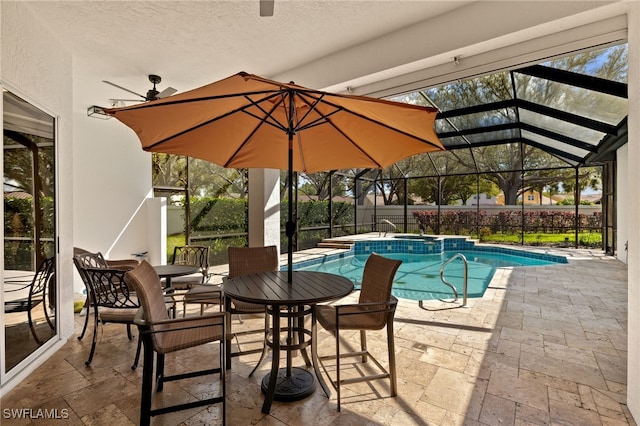 view of swimming pool featuring a pool with connected hot tub, glass enclosure, a patio area, and fence