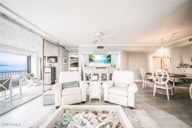 living area featuring ceiling fan with notable chandelier, wood finished floors, visible vents, and crown molding