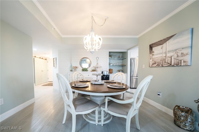 dining space featuring a barn door, ornamental molding, and light wood-style flooring