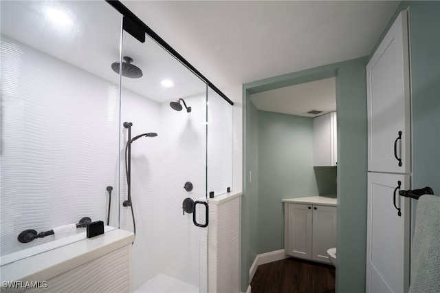 full bathroom with visible vents, a shower stall, vanity, wood finished floors, and baseboards