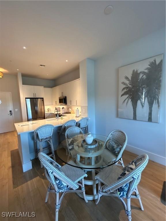 dining room with visible vents, recessed lighting, light wood-style flooring, and baseboards