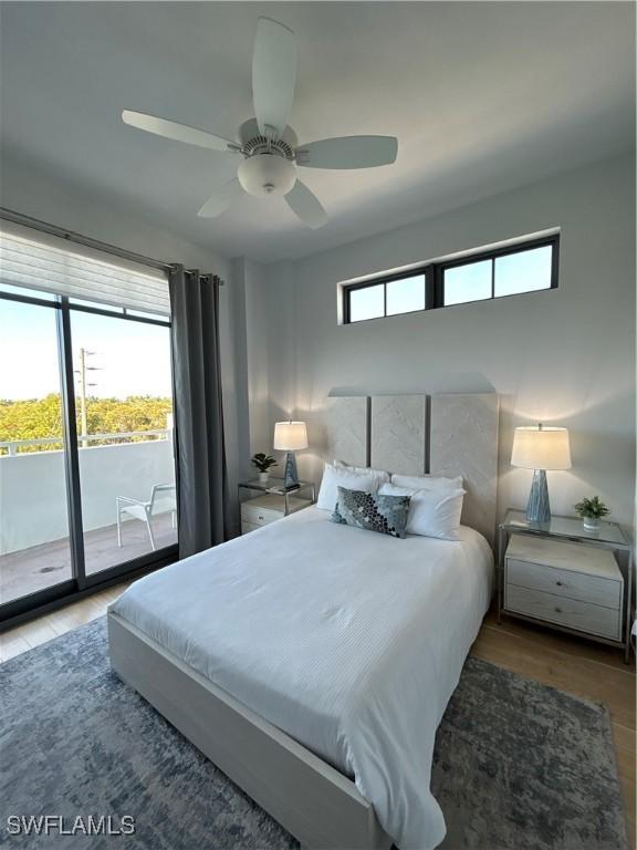 bedroom featuring ceiling fan, access to outside, multiple windows, and wood finished floors