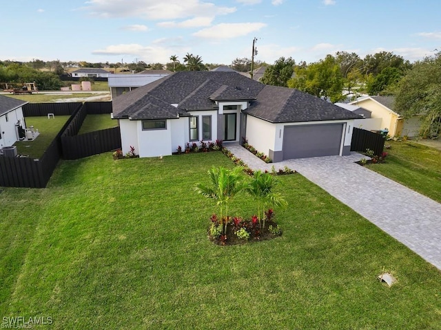 ranch-style home with fence, a front yard, stucco siding, decorative driveway, and a garage