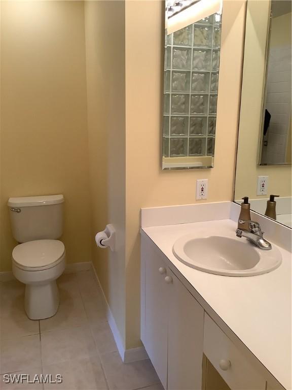 bathroom with baseboards, vanity, toilet, and tile patterned floors