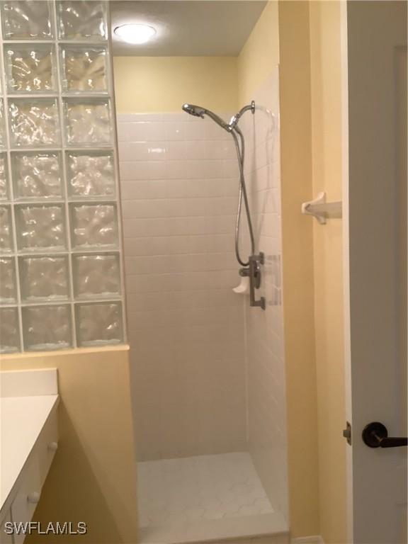 bathroom featuring a tile shower and vanity