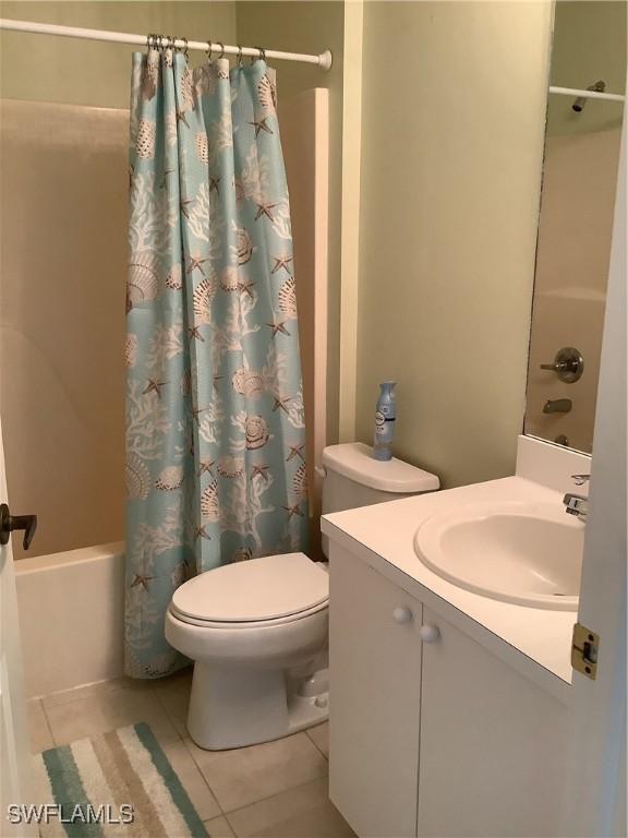 full bath with shower / bath combination with curtain, vanity, tile patterned flooring, and toilet