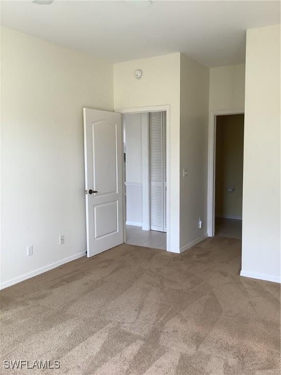 unfurnished bedroom featuring baseboards and carpet flooring