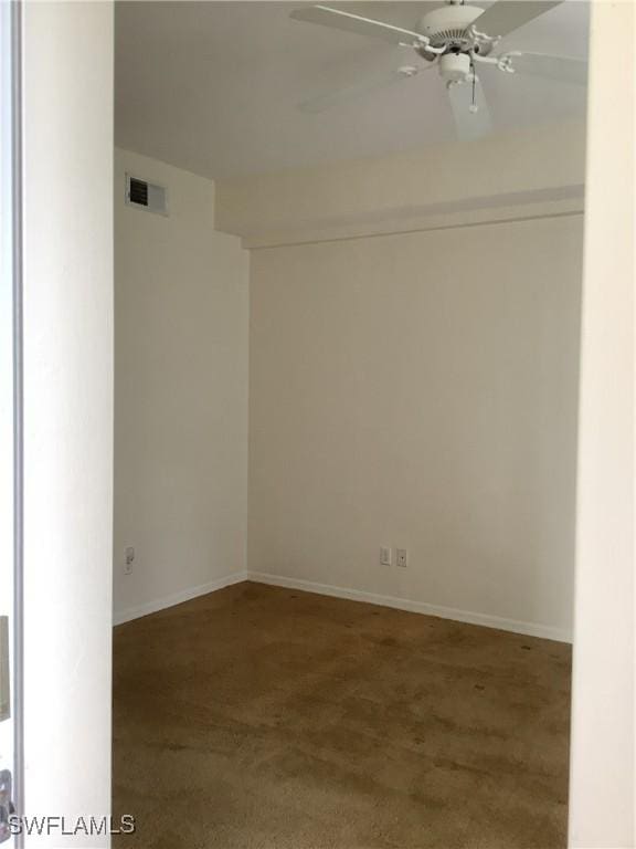 carpeted empty room with a ceiling fan, visible vents, and baseboards