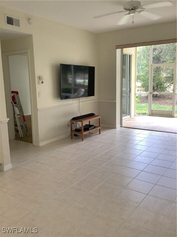 unfurnished living room featuring baseboards, visible vents, a ceiling fan, and light tile patterned flooring