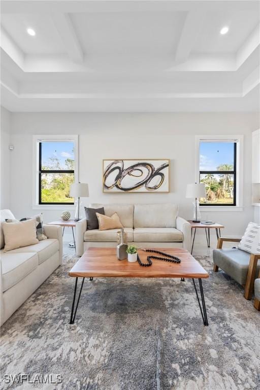 living area featuring beam ceiling, plenty of natural light, and coffered ceiling