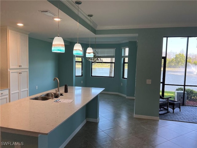 kitchen with plenty of natural light, white cabinets, visible vents, and a sink