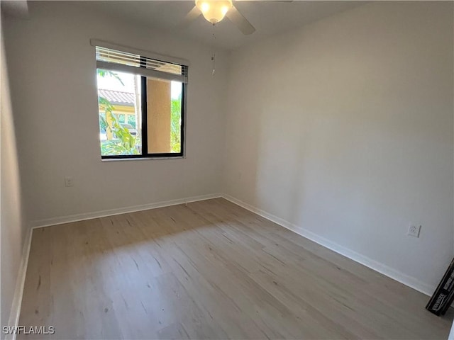 spare room with a ceiling fan, baseboards, and wood finished floors