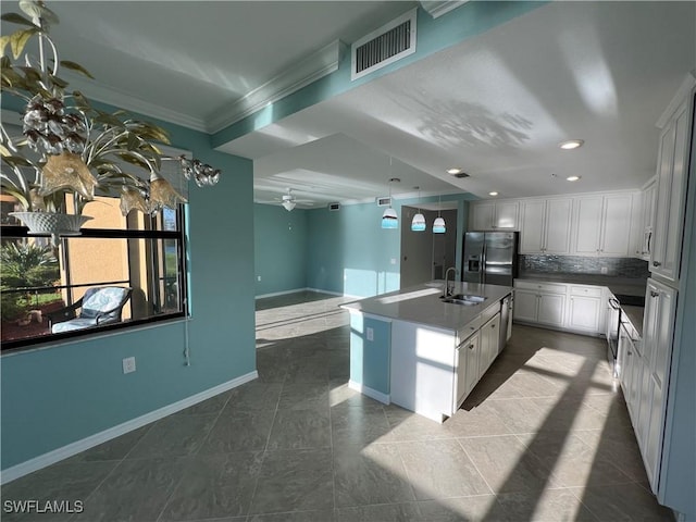 kitchen featuring visible vents, stainless steel refrigerator with ice dispenser, a sink, tasteful backsplash, and open floor plan