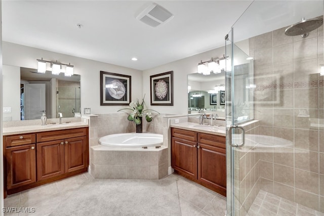 bathroom featuring a garden tub, two vanities, a sink, a shower stall, and tile patterned flooring