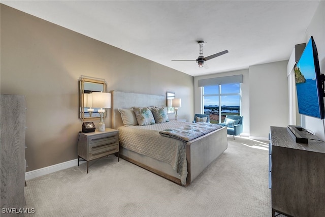 bedroom with ceiling fan, baseboards, and light colored carpet