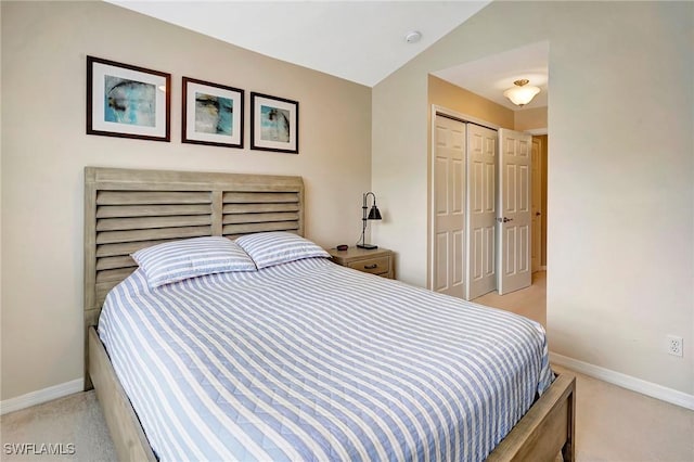 bedroom featuring lofted ceiling, baseboards, a closet, and light colored carpet