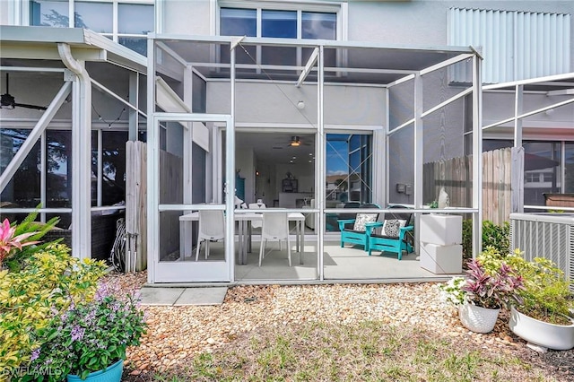 back of property with a lanai, a patio area, central AC, and stucco siding