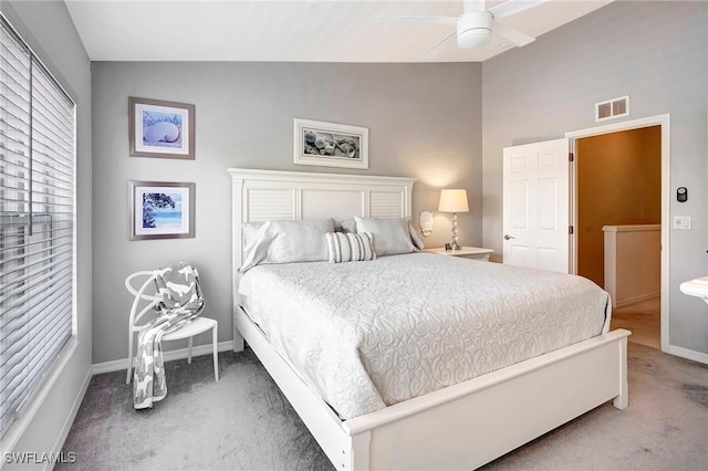 carpeted bedroom featuring baseboards, visible vents, vaulted ceiling, and a ceiling fan