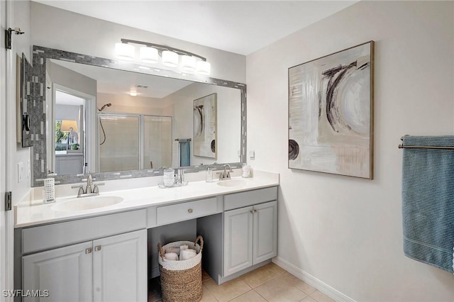 bathroom featuring tile patterned floors, a sink, a shower stall, and double vanity