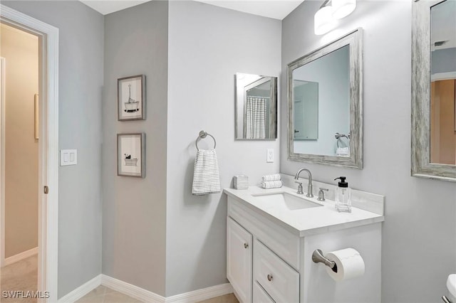 half bathroom featuring toilet, vanity, and baseboards