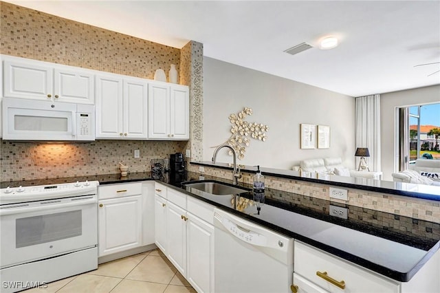 kitchen with white appliances, visible vents, a sink, and decorative backsplash