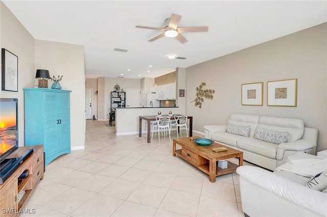 living room featuring light tile patterned floors, ceiling fan, visible vents, and baseboards