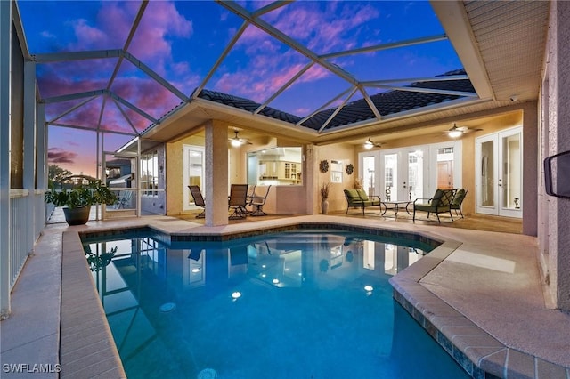 pool with a ceiling fan, a patio, glass enclosure, and french doors