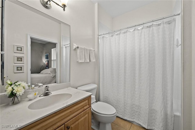 ensuite bathroom with vanity, tile patterned floors, toilet, and connected bathroom