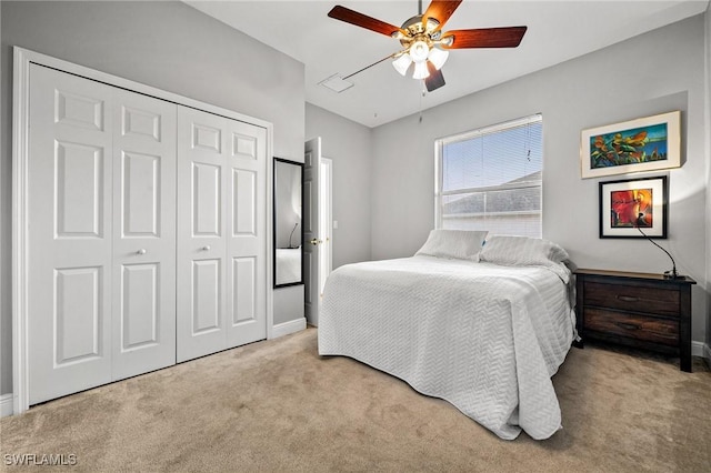 carpeted bedroom with baseboards, a closet, and ceiling fan