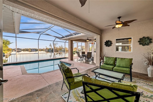 outdoor pool featuring glass enclosure, a patio, fence, a ceiling fan, and an outdoor living space