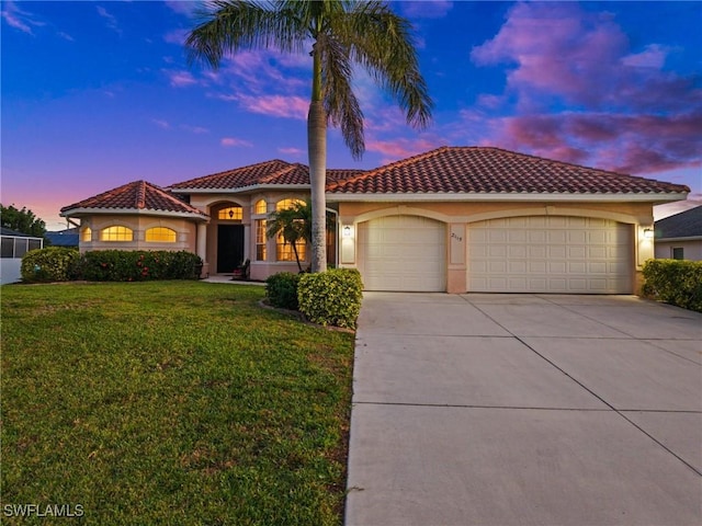 mediterranean / spanish house featuring stucco siding, driveway, a tile roof, a front yard, and an attached garage