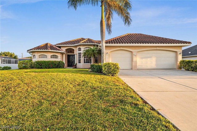 mediterranean / spanish house featuring stucco siding, a front lawn, driveway, a garage, and a tiled roof