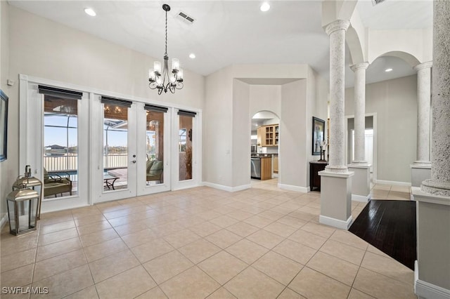 interior space with visible vents, decorative columns, light tile patterned floors, french doors, and arched walkways